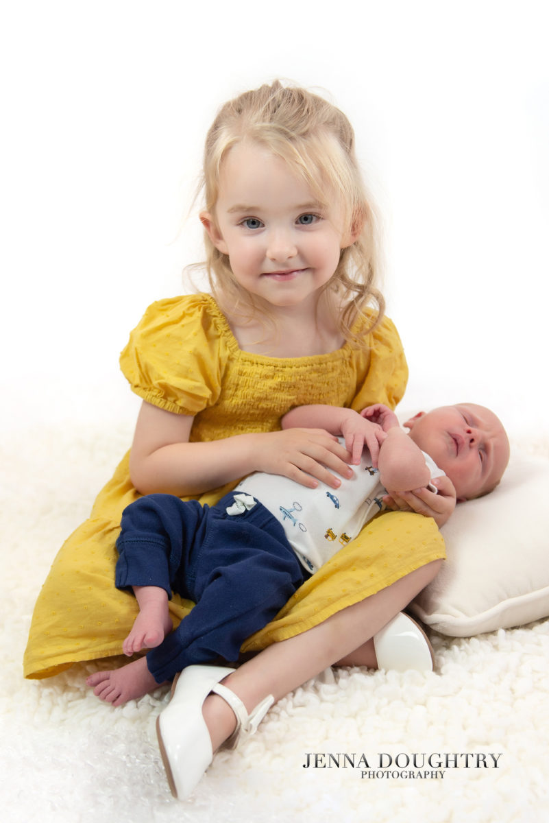 Big sister holding baby brother 