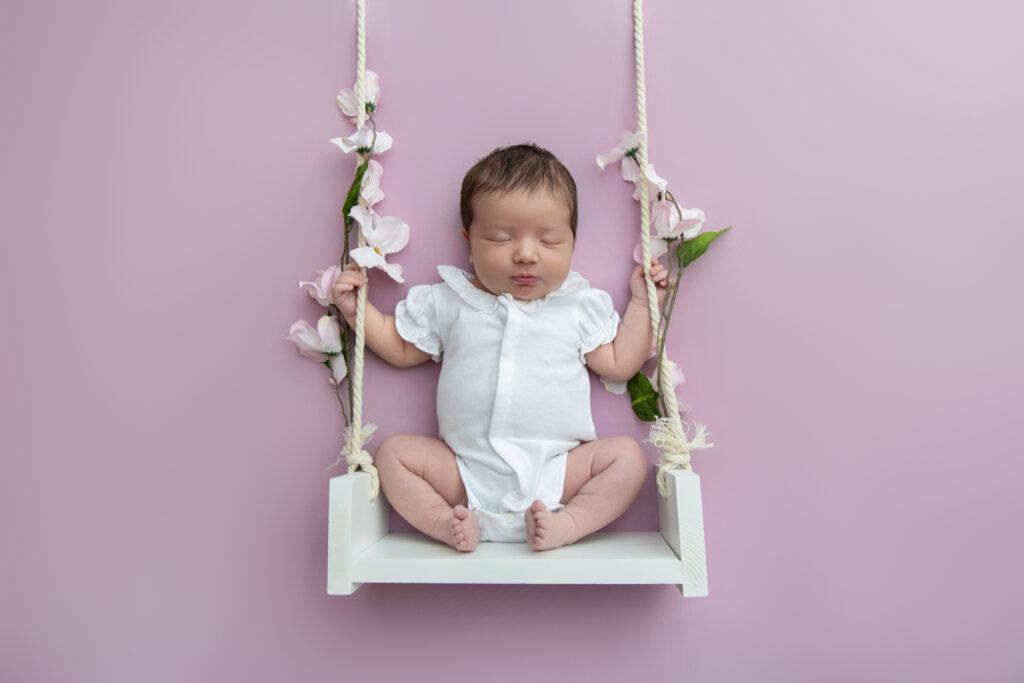 Newborn baby girl on a rope swing in Kennebunk, Maine