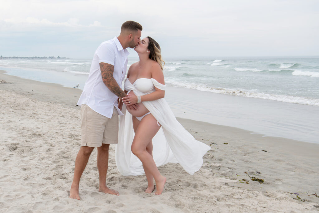 Maternity photographer in Wells Maine captures pregnant woman and her spouse on the beach